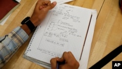 A student writes notes in the Advanced Placement (AP) Physics class at Woodrow Wilson High School in Washington, Friday, Feb. 7, 2014.