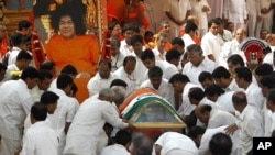 Followers carry the body of spiritual guru Sri Sathya Sai Baba during his funeral inside an ashram at Puttaparti in the southern Indian state of Andhra Pradesh April 27, 2011.