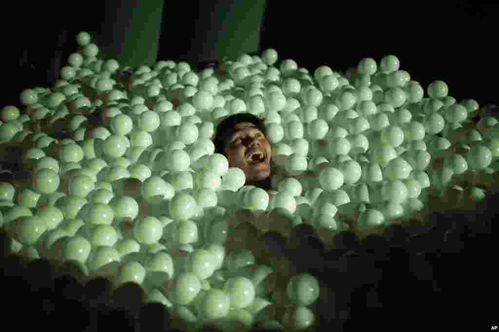 A man is seen in an inflatable play station filled with plastic balls in Singapore.