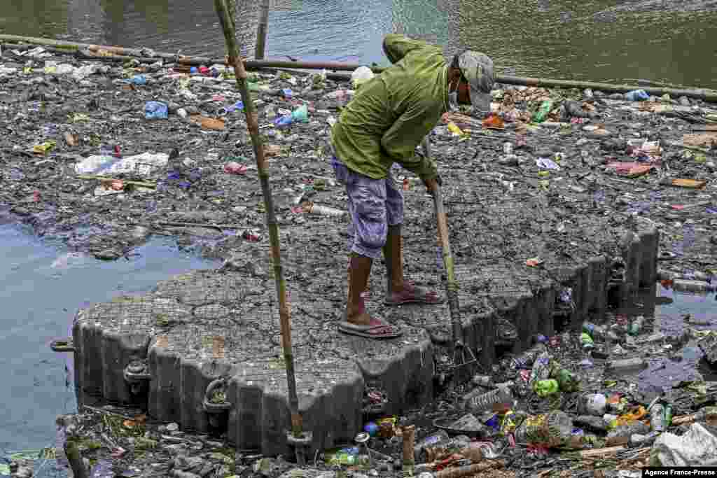 A worker cleans a lake on the outskirts of Colombo, Sri Lanka.