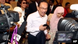Malaysian opposition leader Anwar Ibrahim, center, arrives at court house in Putrajaya, Malaysia Tuesday, Feb. 10, 2015.