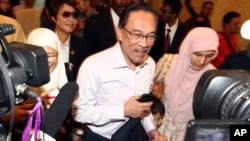 FILE - Malaysian opposition leader Anwar Ibrahim, center, arrives at court house in Putrajaya, Malaysia Tuesday, Feb. 10, 2015.