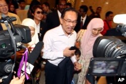 FILE -Malaysian opposition leader Anwar Ibrahim, center, arrives at court house in Putrajaya, Malaysia, Feb. 10, 2015.