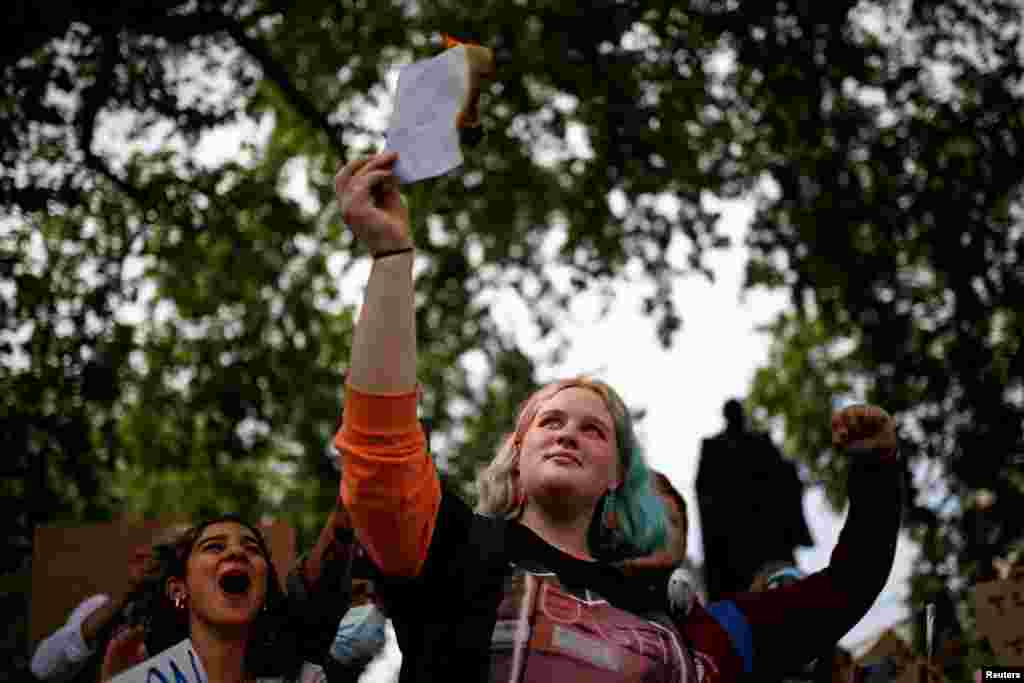 A student burns an A-level result during a protest at Parliament Square in London, Britain, Aug. 16, 2020.