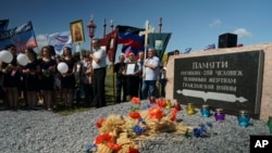 FILE- People attend a memorial service at the crash site of the Malaysia Airlines Flight 17, near the village of Hrabove, eastern Ukraine, July 17, 2015.