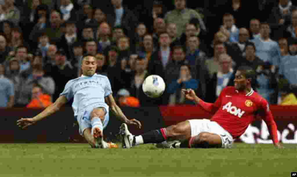 Manchester City's Gael Clichy, left, competes for the ball with Manchester United's Chris Smalling during the English Premier League soccer match between Manchester City and Manchester United at the Etihad Stadium in Manchester, Monday, April 30, 2012. (