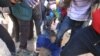 A police officer is assaulted by angry protesters in Harare, Monday, July, 4, 2016. (AP Photo/Tsvangirayi Mukwazhi)