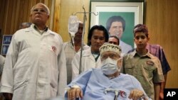 FILE - Libyan Abdelbaset al-Megrahi, is seen below a portrait of Libyan Leader Moammar Gadhafi, at Tripoli Medical Center in Tripoli, Libya, Sept. 9, 2009.