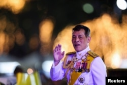 FILE - Thailand's King Maha Vajiralongkorn greets royalists ahead of a candlelight vigil to remember the birthday of Thailand's late King Bhumibol Adulyadej, outside the Grand Palace in Bangkok, Thailand, Dec. 5, 2020.