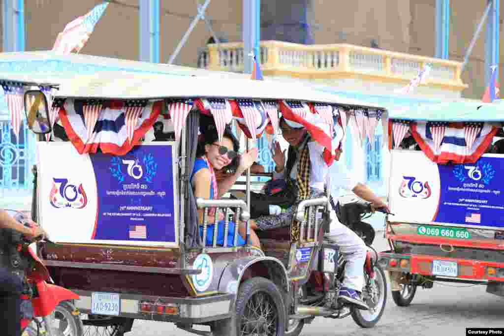 An embassy staff waves from a tuk-tuk during a parade to celebrate 70-years of Cambodia-US relations in Phnom Penh, Cambodia, 2020. (Photo courtesy of U.S. Embassy in Cambodia) 