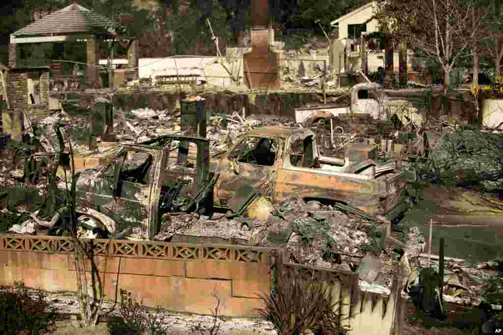 Rubble and burned vehicles line properties scorched by a wildfire, Dec. 6, 2017, in Ventura.