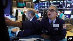 Specialist Anthony Rinaldi, right, works at his post on the floor of the New York Stock Exchange, Aug. 8, 2019. 