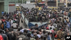 Rebeldes do M23 escoltam soldados do governo e polícias que se renderam num local não revelado em Goma, República Democrática do Congo, quinta-feira, 30 de janeiro de 2025.