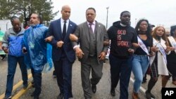 U.S. Sen. Cory Booker, D-N.J., third from left, and the Rev. Jesse Jackson march to cross the Edmund Pettus Bridge Sunday, March 3, 2019, during the Bloody Sunday commemoration in Selma, Alabama. 