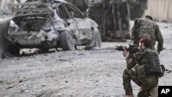 An Afghan soldier secures the scene of a suicide attack at the gate of an airport in Jalalabad, Nangarhar province east of Kabul, Afghanistan, Feb. 27, 2012. 