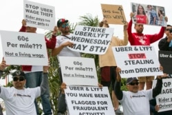 Drivers for ride-hailing giants Uber and Lyft rally at a park near Los Angeles International Airport, May, 8, 2019, in Los Angeles. Some drivers for ride-hailing giants Uber and Lyft turned off their apps to protest what they say are declining wages.