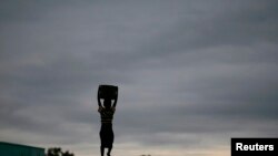 Un enfant porte de l'eau près de Lilongwe, Malawi, le 2 février 2016.