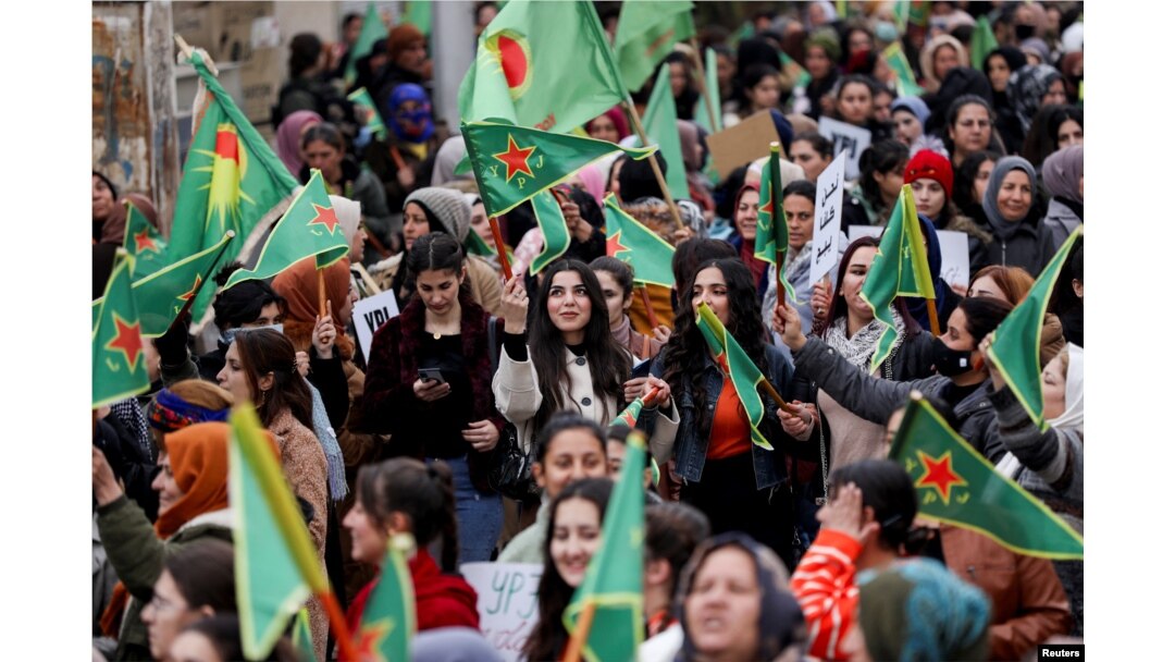 Žene drže zastave Jedinica za zaštitu žena (YPJ) tokom mitinga na kojem se zahtijeva od novih islamističkih vladara u Damasku da poštuju prava žena i osude vojne kampanje koje podržava Turska u regionima na sjeveru koje predvode Kurdi, u Kamišli, Sirija, 23. decembra, 2024.