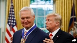President Donald Trump, right, presents the Presidential Medal of Freedom to former NBA basketball player and general manager Jerry West, in the Oval Office of the White House, Sept. 5, 2019.