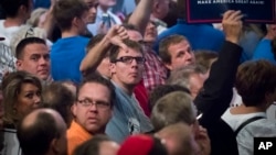 Supporters of Republican presidential candidate Donald Trump react toward reporters and photographers during a campaign rally in Cincinnati, Oct. 13, 2016.