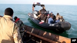 FILE — Migrants board a boat after getting stopped by Tunisian Maritime National Guard at sea during an attempt to get to Italy, near the coast of Sfax, Tunisia, on April 18, 2023. 