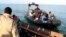 FILE — Migrants board a boat after getting stopped by Tunisian Maritime National Guard at sea during an attempt to get to Italy, near the coast of Sfax, Tunisia, on April 18, 2023. 