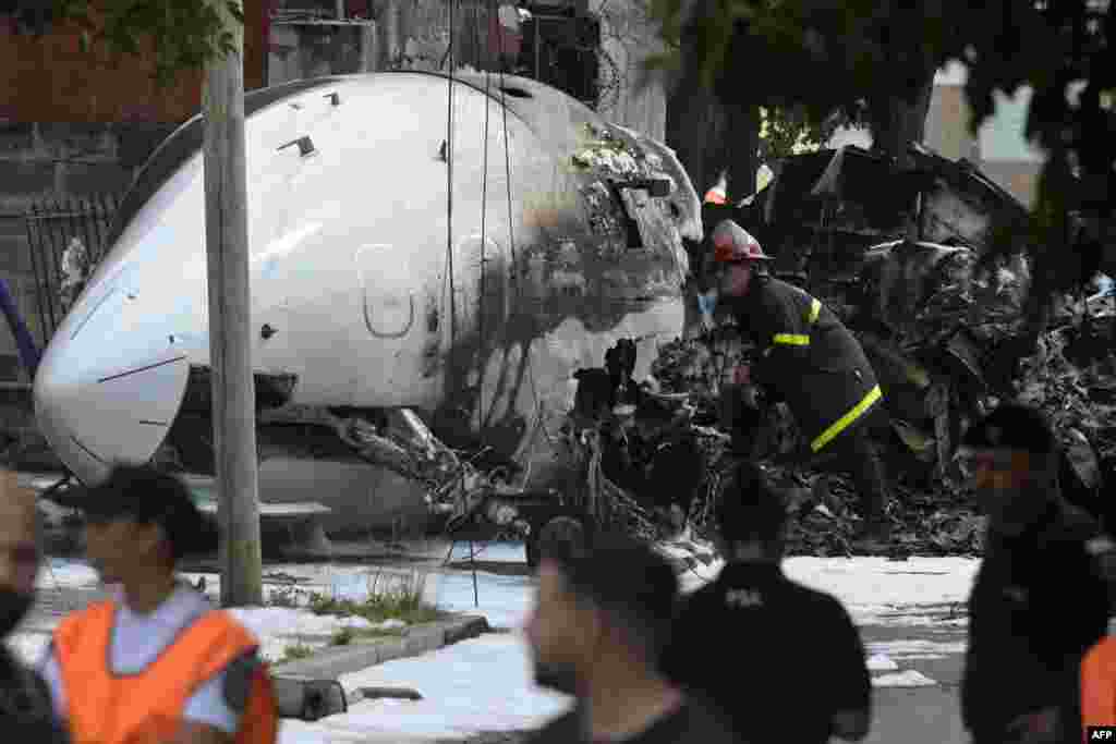 A firefighter inspects the wreckage of a Challenger 300 aircraft that crashed upon landing in the town of San Fernando, Buenos Aires Province, Argentina.&nbsp;The pilot and co-pilot died after the private plane crashed and caught fire near the airport of San Fernando. No other injuries were reported.