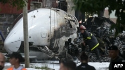 A firefighter inspects the wreckage of a Challenger 300 aircraft that crashed upon landing in the town of San Fernando, Buenos Aires Province, Argentina.&nbsp;The pilot and co-pilot died after the private plane crashed and caught fire near the airport of San Fernando. No other injuries were reported.