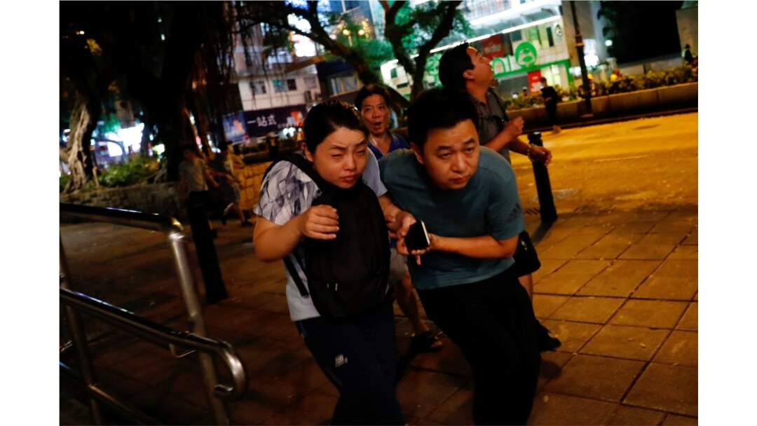 Tourist react as riot police fire tear gas to anti-extradition bill protesters at Tsim Sha Tsui after a demonstration in Hong Kong, Aug. 10, 2019.