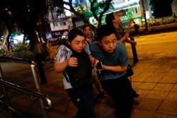 Tourist react as riot police fire tear gas to anti-extradition bill protesters at Tsim Sha Tsui after a demonstration in Hong Kong, Aug. 10, 2019.