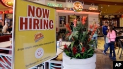 FILE - A restaurant posts a sign hoping to draw in job applicants, in Miami, Florida, Feb. 9, 2016. The Labor Department reported Friday that the U.S. economy had a net gain of 235,000 jobs for the month of February. 