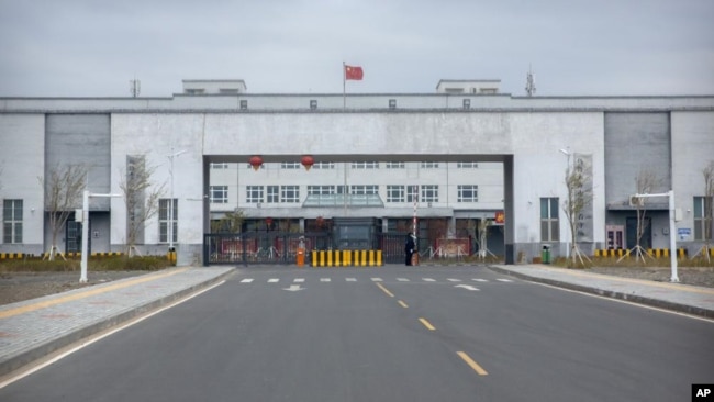 FILE - Police officers stand at the outer entrance of the Urumqi No. 3 Detention Center in Dabancheng in western China's Xinjiang Uyghur Autonomous Region, April 23, 2021.
