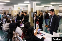 Orang-orang berkumpul di Sekolah Dasar Nathan Straus P.S. 140 untuk memberikan suara dalam pemilihan presiden AS 2024, pada hari pemilihan di Manhattan, Kota New York, AS, 5 November 2024. (Foto: Reuters)