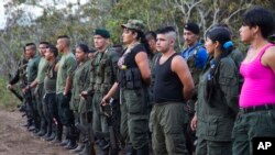 FILE - Rebels of the Revolutionary Armed FOrces of Colombia, FARC, stand on formation at their camp next to the site where is the group is holding it's 10th conference in the Yari Plains, Colombia, Sept. 17, 2016. 