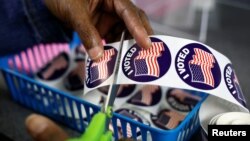 A poll worker prepares "I voted" stickers for voters at the City Clerk's Office ahead of the midterm election in Lansing, Michigan, U.S., Nov. 7, 2022.