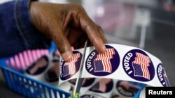 Працівник виборчої дільниці готує наклейки «Я проголосував» для виборців у штаті Мічиган, США, 7 листопада 2022 р. REUTERS/Evelyn Hockstein