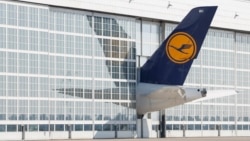 Ekor pesawat Lufthansa tampak mencuat dari hanggar di bandara Franz Josef Strauss di Munich, Jerman selatan. (AFP)&nbsp;