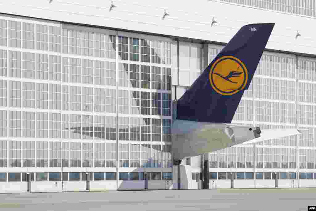 The tail of a Lufthansa airplane sticks out of a hangar at the Franz Josef Strauss airport in Munich, southern Germany.