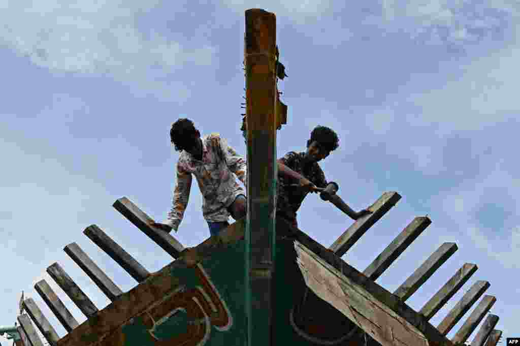 Workers conduct maintenance on a fishing vessel at Kasimedu harbor after the Indian government eased lockdown restrictions implemented because of the coronavirus pandemic, in Chennai, India.