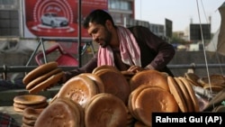 An Afghan street vendor sells bread before the Iftar meal that breaks the fast during the Muslim holy month of Ramadan, Kabul, Afghanistan, June 5, 2018.