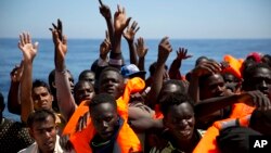 Des migrants et réfugiés reçoivent des gilets de sauvetage de l'ONG espagnole Proactiva Open Arms, après avoir été secourus alors qu'ils dérivaient à bord d'un canot pneumatique en mer Méditerranée, au large de Sabratha, Libye, 15 juin 2017.