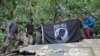 Members from Defense POW/MIA Accounting Agency (DPAA), hold the POW/MIA flag above a piece of metallic debris during a DPAA investigation mission near Bhismaknagar Village, Arunachal Pradesh, India, Dec. 02, 2016. 