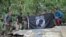 Members from Defense POW/MIA Accounting Agency (DPAA), hold the POW/MIA flag above a piece of metallic debris during a DPAA investigation mission near Bhismaknagar Village, Arunachal Pradesh, India, Dec. 02, 2016. 
