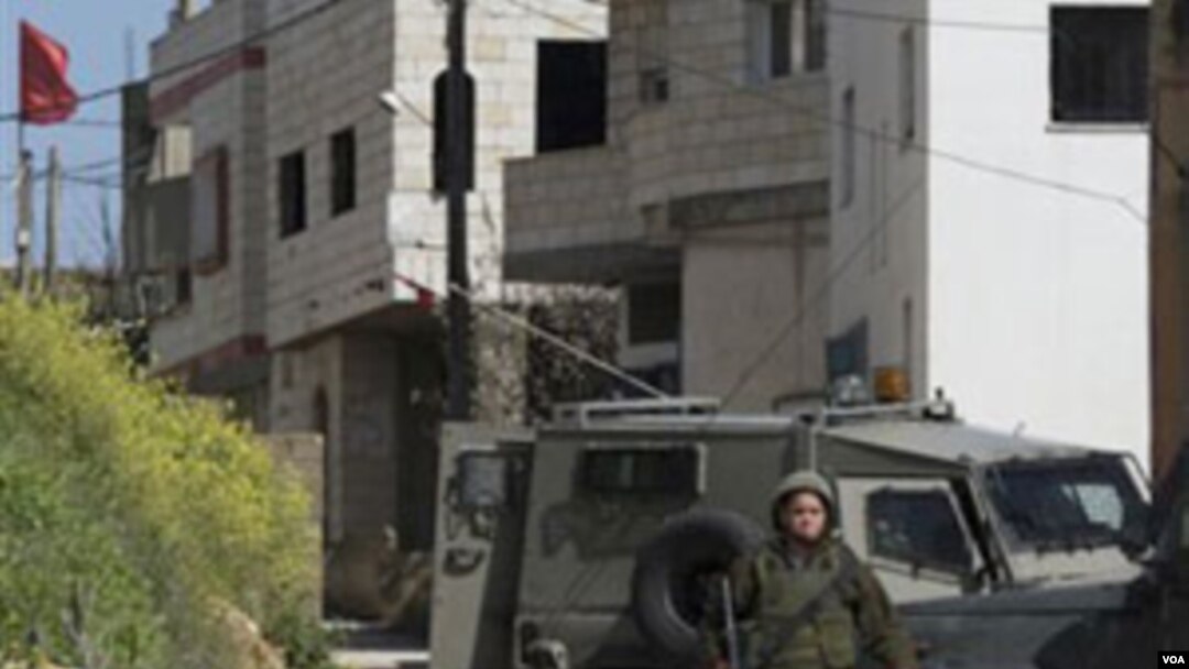 Tentara Israel berpatroli di perkampungan Awarta, Sabtu (12/3) setelah sebuah keluarga dibunuh di dekat Itamar, salah satu pemukiman Yahudi di Tepi Barat.