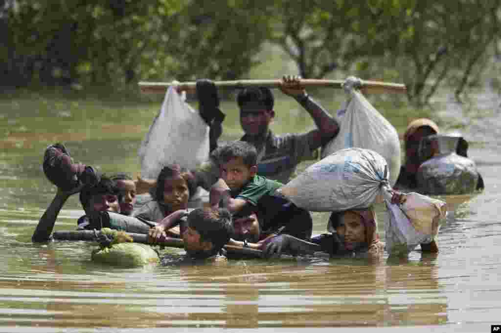 미얀마 &#39;로힝야&#39;족 일가족이 나프강을 넘어 방글라데시 국경으로 향하고 있다. 최근 격화된 미얀마군과 로힝야족 충돌로 15만명이 넘는 난민이 발생한 것으로 추산된다.
