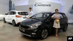 FILE - Models pose next to Kia Motors Corp.'s New Carens during its unveiling in Seoul, South Korea, July 26, 2016.
