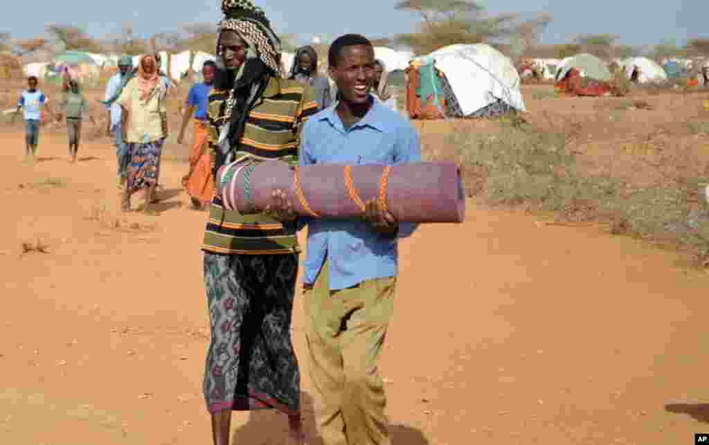 2011年7月21日，在达加哈雷难民营外围，一位父亲抱着死去的孩子准备埋葬。