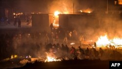 Des migrants sont évacués après un géant incendie dans le camp de Grande-Synthe dans la ville de Dunkirk, 10 avril 2017.