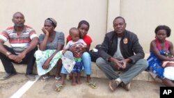 Correspondente da VOA (2º à direita) com a família de Alves Kamulingue, incluindo o seu primo, a sua mãe, a esposa, Elisa, o filho de 2 anos, e Tetê, esposa de Isaías Cassule.