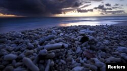 FILE - Dried coral lies on a beach as the sun sets on Lady Elliot Island, 80 kilometers northeast of Bundaberg in Queensland, Australia, June 10, 2015.